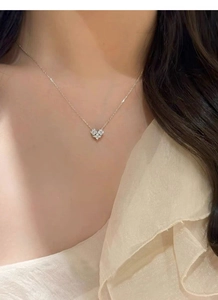 Detail view of a sparkling S925 sterling silver heart pendant necklace on a female collarbone