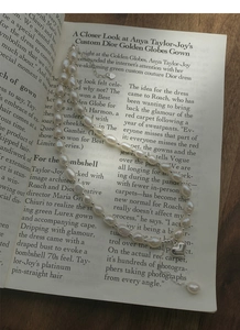 Dettaglio della collana di perle barocche con ciondolo a cuore su un libro