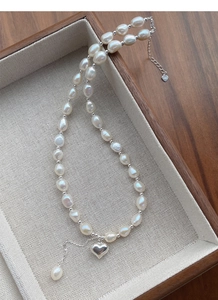 Dettaglio del ciondolo a cuore in argento S925 con collana di perle barocche fini
