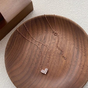 Elegant rose gold S925 sterling silver heart necklace with pave setting on dark wood