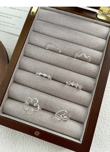 Detailed view of six S925 sterling silver rings with heart and bow motifs in a jewelry box