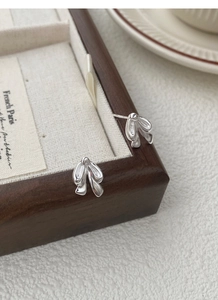 Macro shot of S925 sterling silver bow tie stud earrings with polished mirror finish