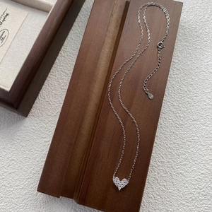 S925 sterling silver heart necklace with sparkling pavé stones on a wooden display