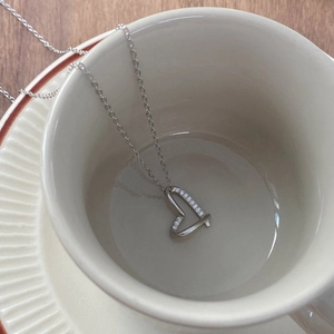 Elegante S925 Sterlingsilber Herzkette mit funkelndem Zirkon auf einer Keramiktasse