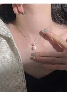 Close-up of S925 sterling silver necklace with teardrop freshwater pearl on collarbone