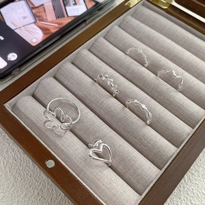 Set of 6 minimalist S925 silver rings with heart and bow designs in a wooden jewelry box