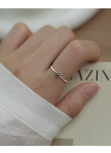 Gros plan sur bague en argent S925 avec un délicat motif floral en zircon noir