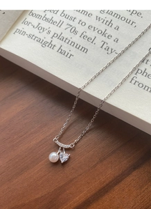 Macro d'un pendentif cerise en argent avec perle d'eau douce et oxyde de zirconium cœur