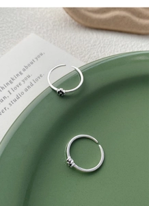 Détails de bagues en argent avec fleurs noires sur une assiette en céramique