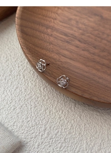Détail de boucles d'oreilles rose évidées en argent avec zircone cubique scintillante