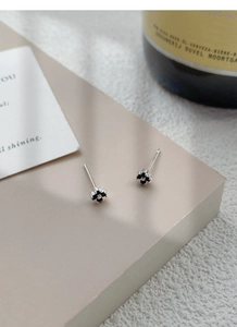 Macro shot of minimalist S999 sterling silver black four-leaf clover stud earrings