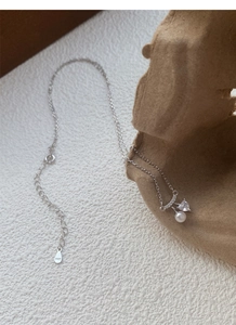 Vue macro d'un collier en argent S925 avec une perle d'eau douce et une pierre de cœur