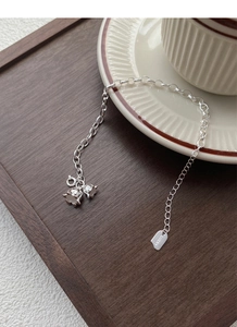 Detail of silver lily of the valley charms and engraved LUCKY tag on the bracelet