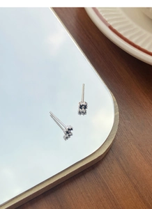 Macro shot of S999 silver black flower stud earrings with S925 hallmark on polished base