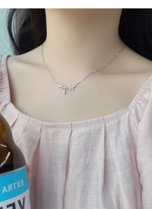 Detailed close-up of a leaf-shaped silver necklace with zircon and a teardrop pendant