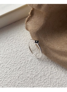 Détail d'une bague en argent S925 avec fleur en zircon noir et anneau ouvert ajustable