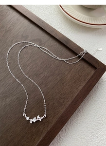 Détail du pendentif feuille de ginkgo en argent 999 avec une texture brossée délicate