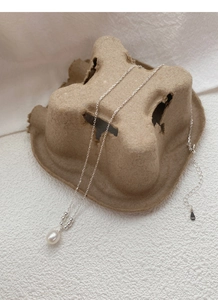 Close-up of S925 sterling silver chain with teardrop pearl and small heart metal tag