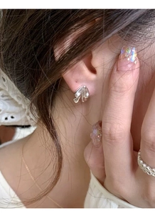 Detailed view of elegant silver bow tie earrings worn with a minimalist style