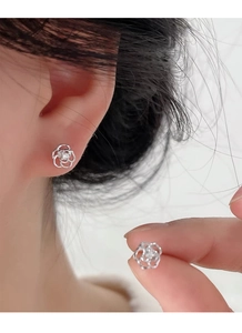 Vue détaillée des boucles d'oreilles rose en argent S999 avec pétales ajourés et zircon