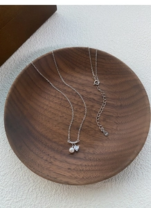Détail du poinçon S925 sur collier en argent avec perle cerise et pendentif zircon