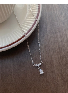 Détail du pendentif goutte en argent avec trois oxydes de zirconium sur céramique