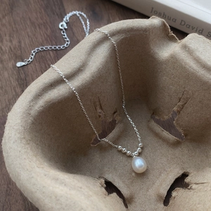 S925 sterling silver necklace with a teardrop freshwater pearl pendant on a minimalist tray