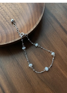 Macro detail of S925 sterling silver chain bracelet with five white freshwater pearls