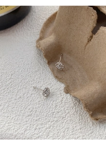 Détail macro de boucles d'oreilles rose en argent S999 avec pétales ajourés et zircon