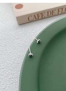 Macro shot of S999 silver four-leaf clover stud earrings with black petals for women