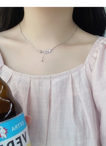 Close-up of S999 sterling silver wheat ear necklace with tassel and zircon on a model