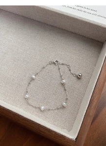 Detailed close-up of S925 silver bracelet with five white freshwater pearls on a display box