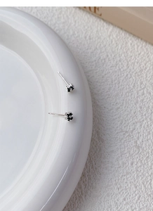 Close-up of S999 sterling silver black clover earrings with fine enamel details