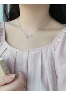 Macro detail of S999 silver necklace with sparkling leaf charm and water drop pendant