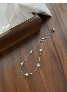 Close-up of minimalist S925 sterling silver chain bracelet with five round freshwater pearls
