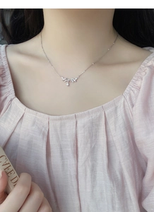Detail of S999 silver olive leaf necklace with pear-cut zircon on model's neck