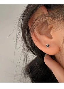 Close-up of minimalist S999 sterling silver black four-leaf clover flower stud earrings