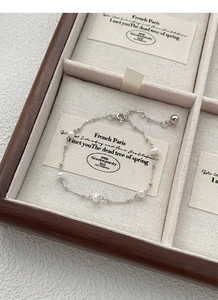 Macro shot of S925 sterling silver freshwater pearl bracelet with delicate chain and clasp