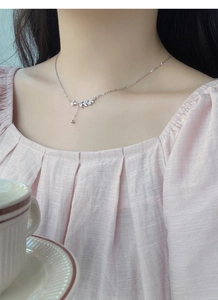 Close-up of S999 sterling silver wheat ear necklace with sparkling white zircons on model