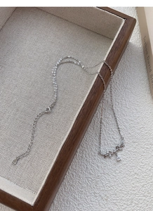 Detail of S925 sterling silver wheat necklace with crystal teardrop on linen tray