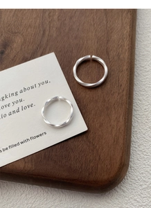 Detail showing matte silver Mobius rings with frosted texture and adjustable open design