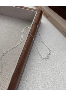 Détail macro des pendentifs en feuilles de ginkgo en argent sur une chaîne fine élégante
