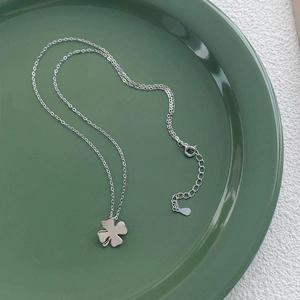 Halskette aus S925 Sterlingsilber mit poliertem Kleeblatt-Anhänger auf grünem Tablett