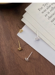 Vue détaillée de boucles d'oreilles nuages en argent doré et argenté sur un fond en bois