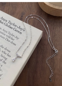 Vue macro détaillée du collier avec pendentif goutte en argent sterling S925 sur un livre