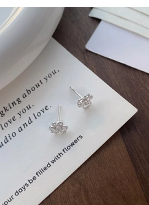Detailed macro shot of S999 sterling silver clover stud earrings with sparkling cubic zirconia