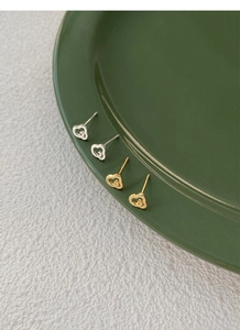 Détails macro de boucles d'oreilles en argent S999 et or en forme de cœur évidé