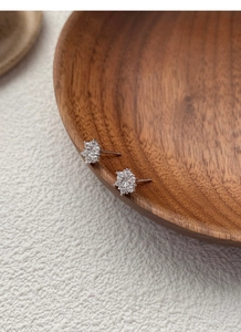 Macro detail of S925 sterling silver snowflake stud earrings with sparkling cubic zirconia