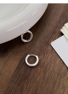 Détail de créoles en argent S999 brossé mat avec texture minimaliste et fermoir à anneau