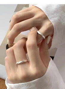 Macro shot of silver Mobius rings with matte finish worn together on model's hand